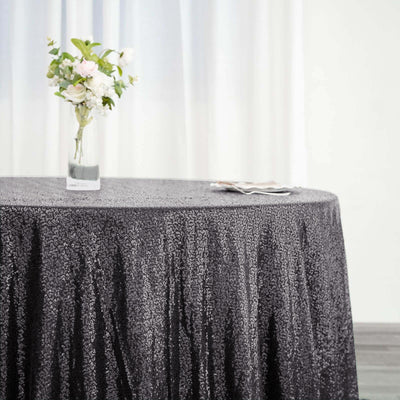 Elegant black tablecloth on a dining table with floral centerpiece.