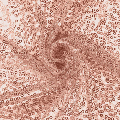 Rose gold sequin fabric with a shimmering texture in a swirling pattern.