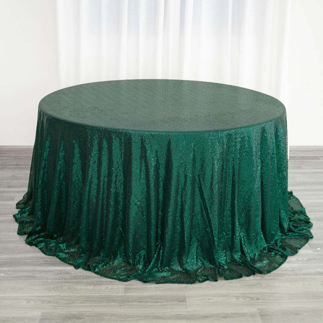 Green sequined tablecloth draped elegantly over a round table.