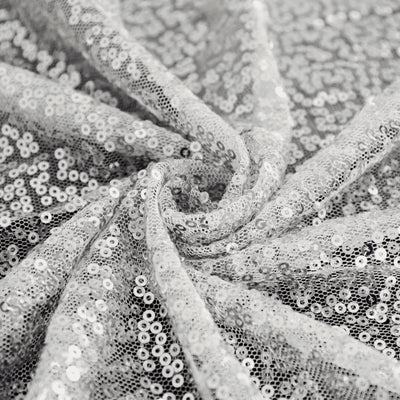Silver sequined fabric with a shimmering texture in a swirl pattern. #whtbkgd