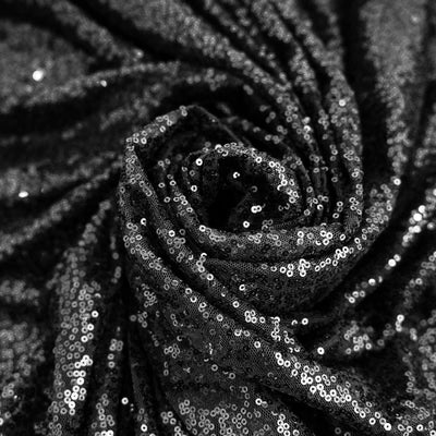 Black sequin fabric draped in a spiral pattern. #whtbkgd