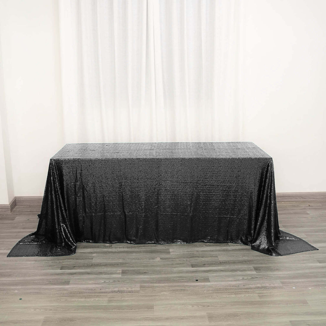 Black sequin tablecloth draped over a table in a studio setting.