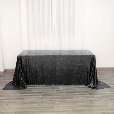 Black sequin tablecloth draped over a table in a studio setting.