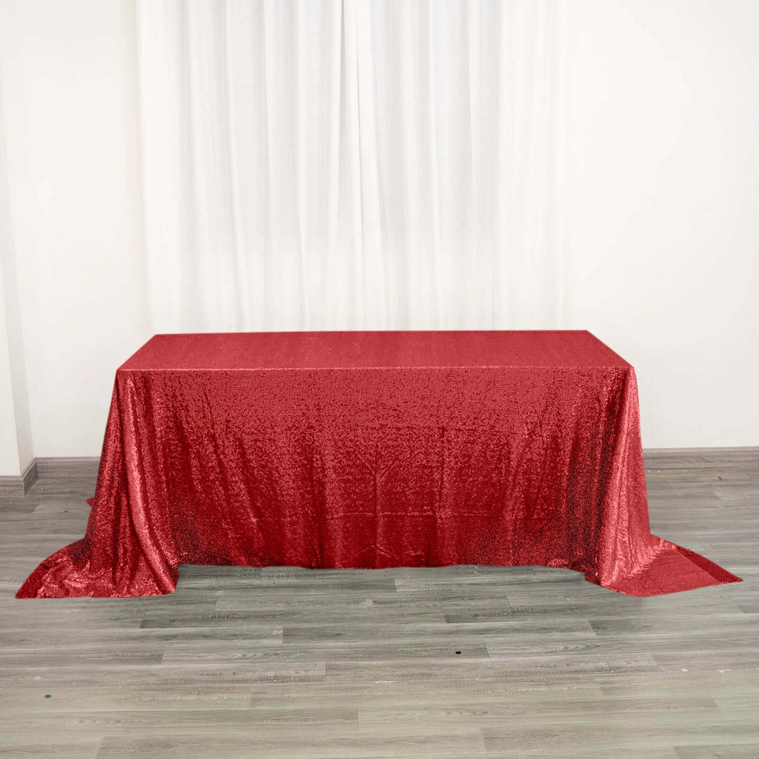 Red sequin tablecloth draped over a table in a bright setting.