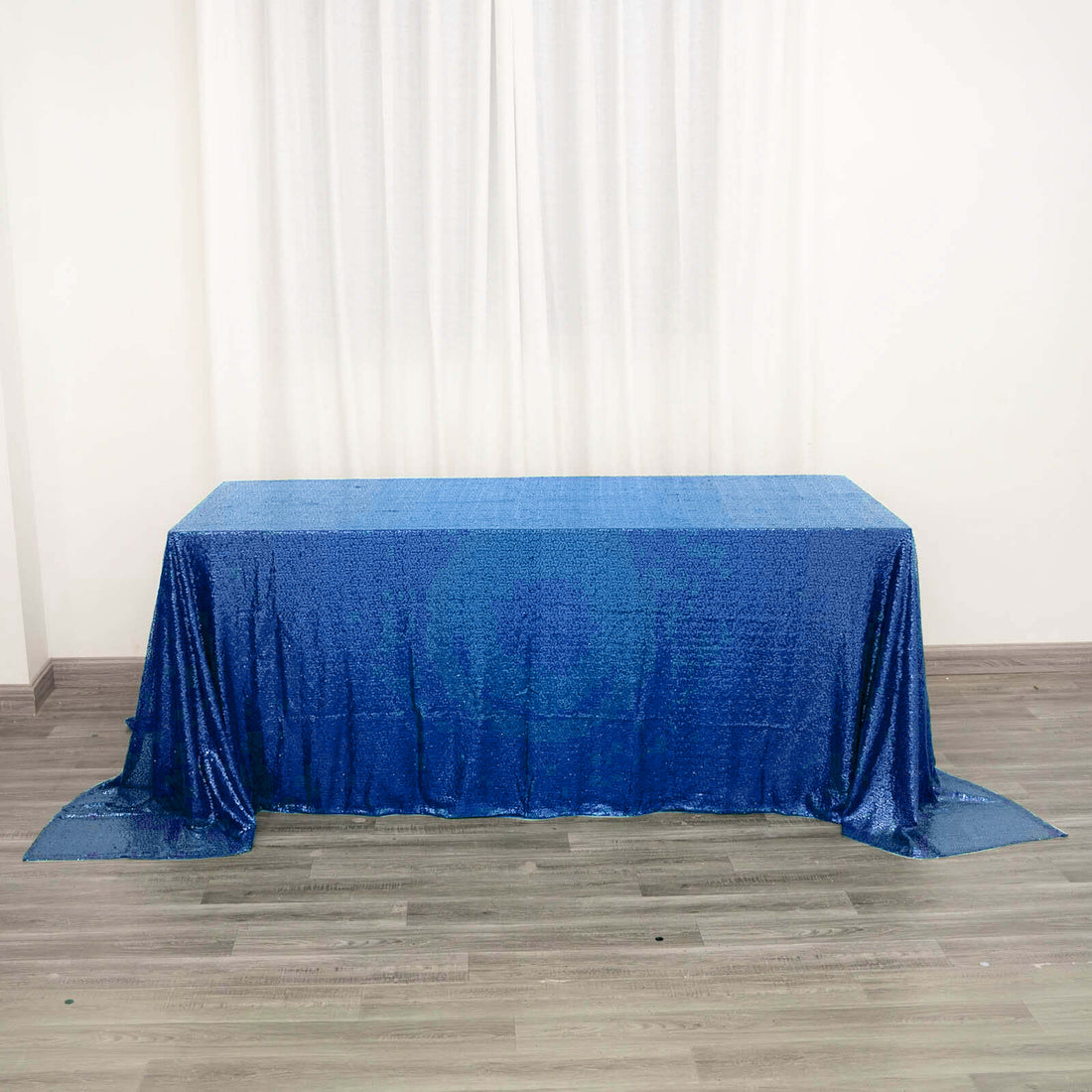 Blue sequin tablecloth draped on a table in a bright setting.