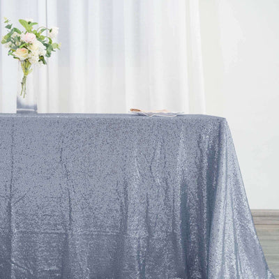 Silver sequin tablecloth on a table with a vase of flowers.