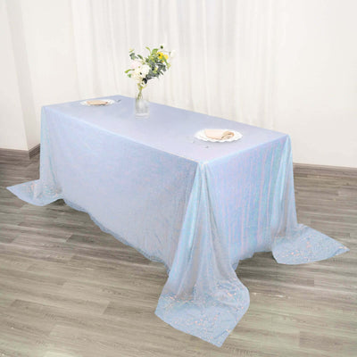 Iridescent tablecloth draped elegantly over a table with floral centerpiece.