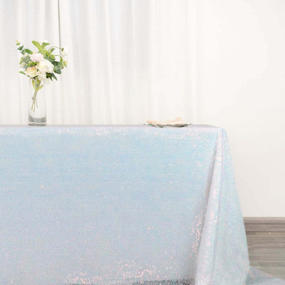 Iridescent tablecloth draping elegantly over a table with a floral arrangement.
