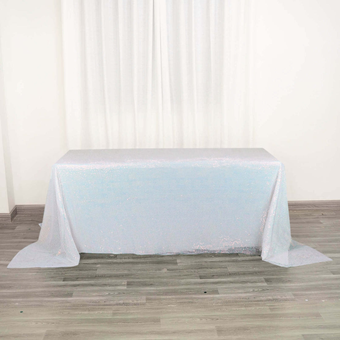 Shimmering iridescent tablecloth draped over a table in a studio setting.