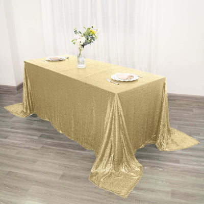 Gold sequin tablecloth draped over a table in a bright setting.