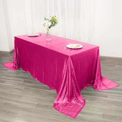 Pink sequin tablecloth draped elegantly over a table with floral centerpiece