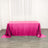 Pink sequined tablecloth on a wooden floor with white curtains.