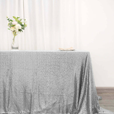 Silver sequin tablecloth draped elegantly over a table with a floral centerpiece.