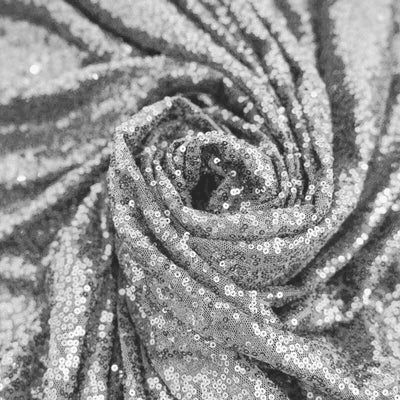 Shimmering silver sequin fabric rolled into a spiral pattern. #whtbkgd
