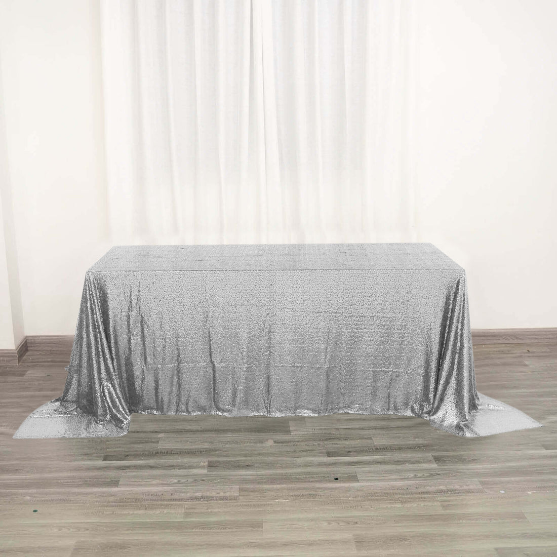 Silver sequin tablecloth on a plain table in a bright room