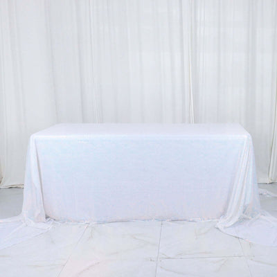 White sequin tablecloth draped over a table in a studio setting.