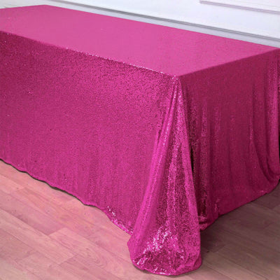 Pink sequin tablecloth draped over a table in a bright setting.