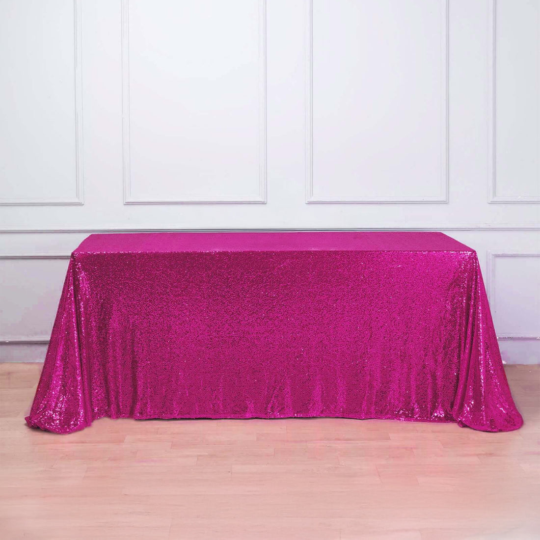 Pink sequin table cover on a plain backdrop.