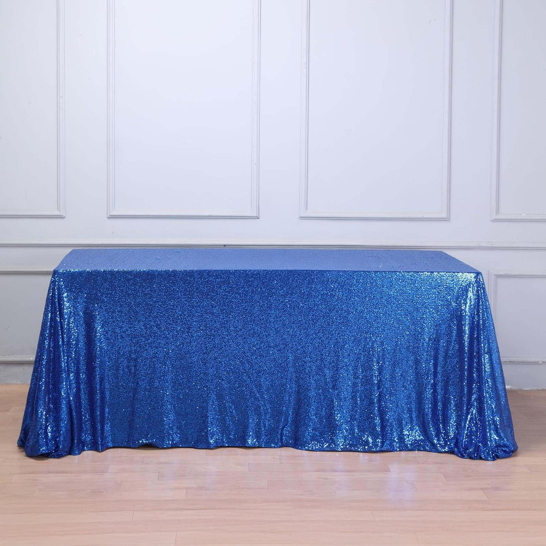Blue sequin tablecloth draped over a table against a plain background.