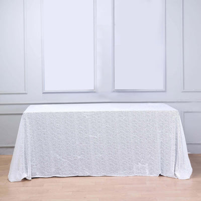 White lace tablecloth on a wooden table in a bright setting.