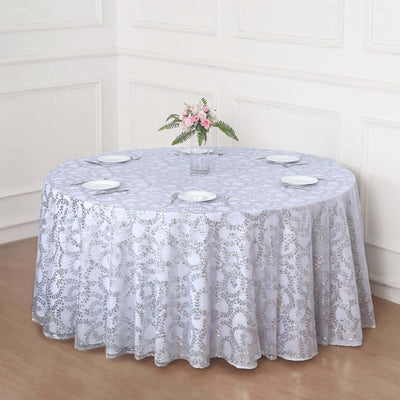 Round lace tablecloth on a dining table with plates and a flower vase.