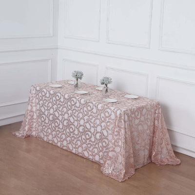 Elegant rose gold sequined tablecloth draped over a table with floral centerpieces.