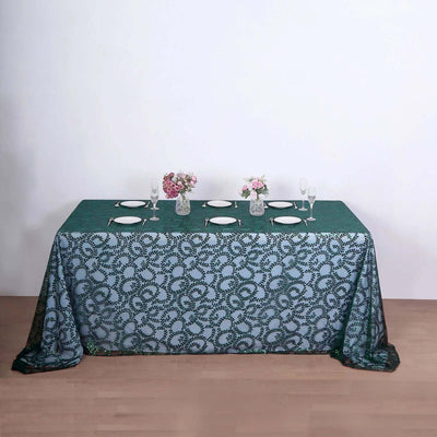 Elegant green and white tablecloth with floral design for dining settings.
