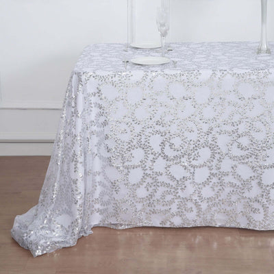White tablecloth with silver floral pattern draped elegantly over a table.
