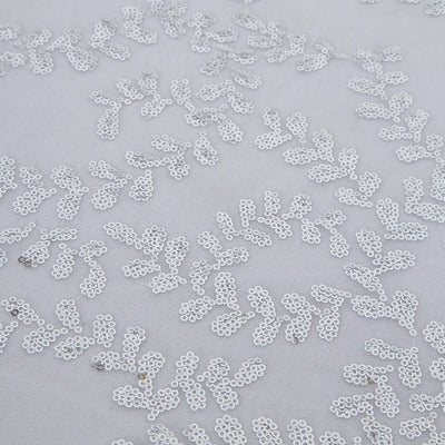 Silver sequin leaf pattern on a light fabric background.