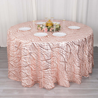 Rose gold patterned tablecloth draped over a round table with decorative accents.