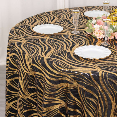 Gold wave pattern tablecloth on a round table with white plates and floral arrangement.