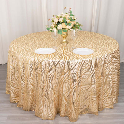Gold patterned tablecloth with elegant floral centerpiece on a round table.