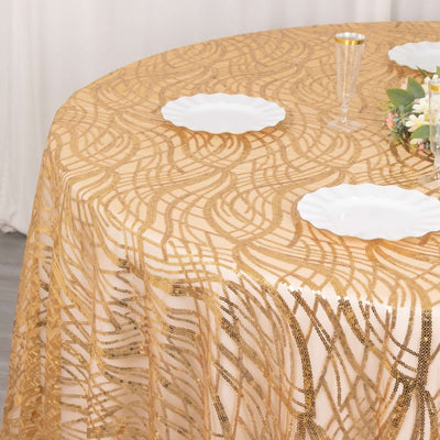 Elegant gold lace tablecloth on a table with white plates and floral decor.