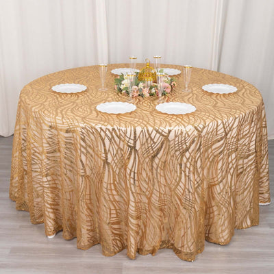 Elegant round table with a gold patterned tablecloth and white plates.