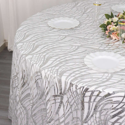 Elegant white tablecloth with silver wave pattern on a round table.