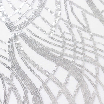 Silver sequin fabric with intricate wave patterns.