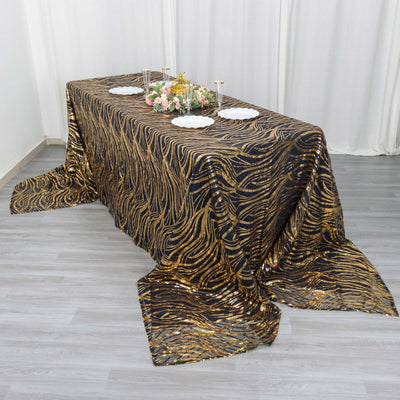 Elegant black and gold patterned tablecloth draped over a dining table.