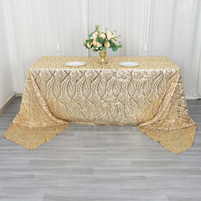 Gold sequin tablecloth on a table with floral arrangement centerpiece.