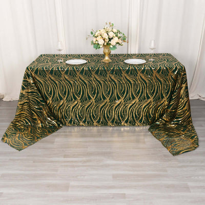 Green and gold patterned tablecloth draped over a table with floral centerpiece.