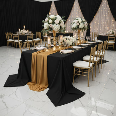 Elegant banquet setup with gold and black decor, floral centerpieces, and candlelight.