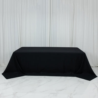 Black tablecloth draped over a rectangular table in a studio setting.