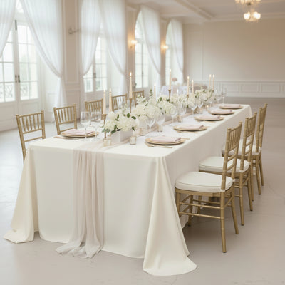 Elegant banquet table set with white flowers and candles in a luxurious venue.