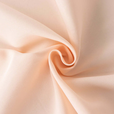 Close-up of soft peach fabric with gentle folds and texture.