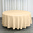 Round beige tablecloth on a table in a bright setting.