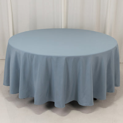 Round blue tablecloth on a table with draped edges.