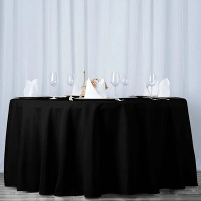 Elegant black tablecloth on a dining table set for a formal meal.