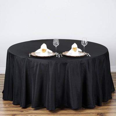 Elegant black round table set for two with plates and glasses.