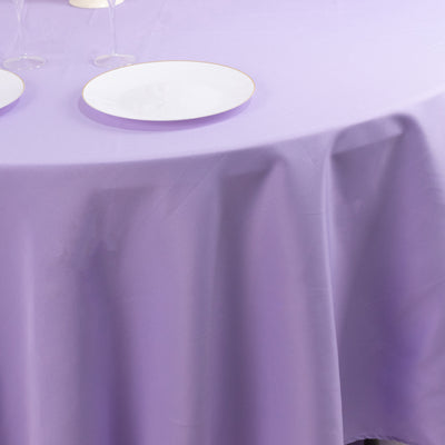 Purple tablecloth draped over a table with white plates.