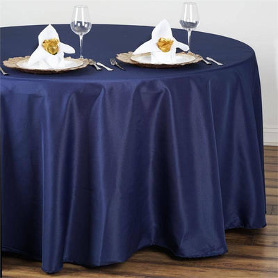Navy tablecloth draped over a round table set with elegant dinnerware.