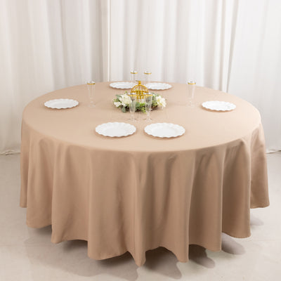 Round table set with elegant plates and decorative centerpiece.